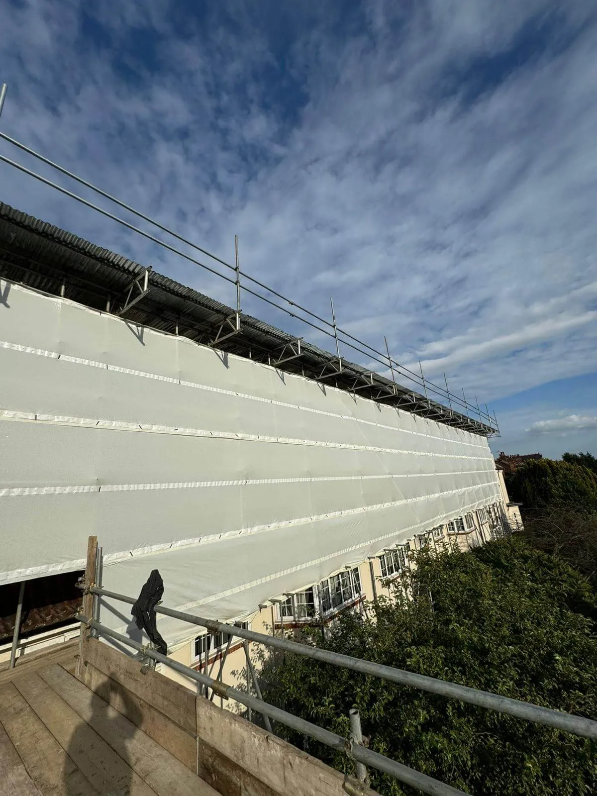 Temporary roof scaffolding with fully sheeted encapsulation keeping a building watertight during roof works