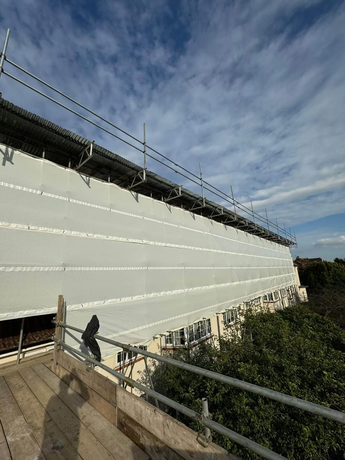 Temporary roof scaffolding with fully sheeted encapsulation keeping a building watertight during roof works
