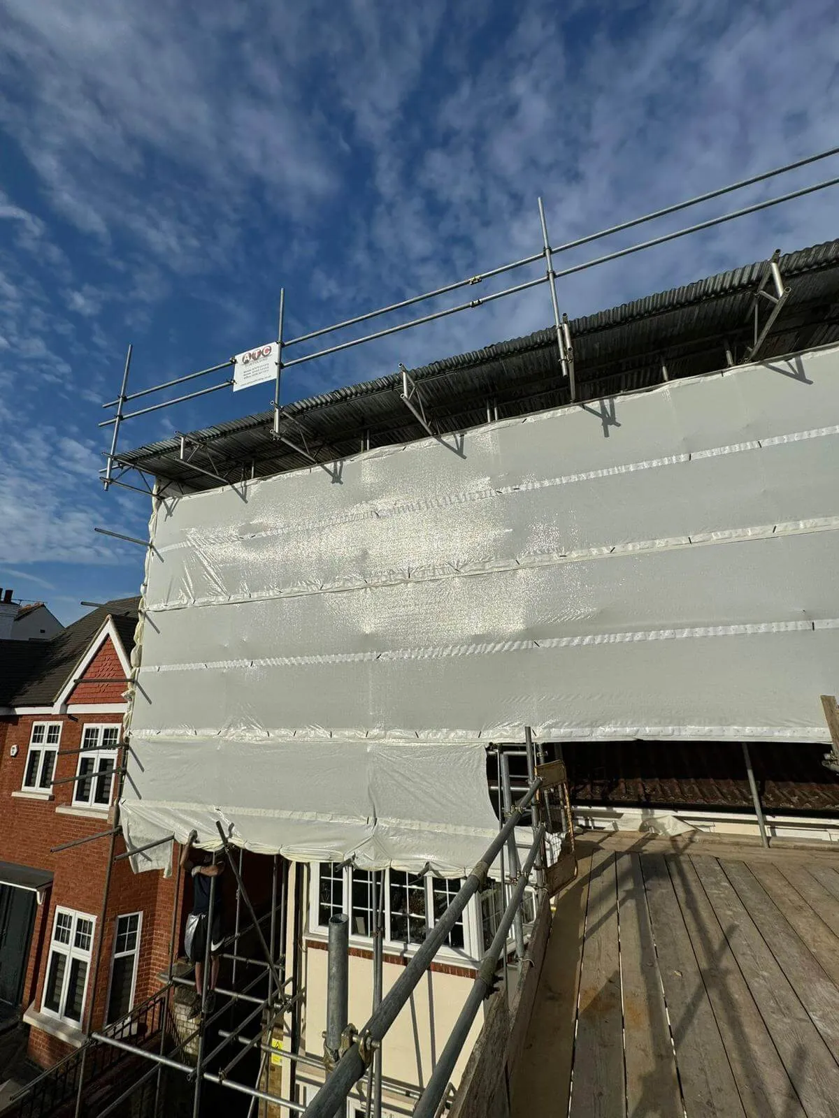 Temporary roof scaffolding with fully sheeted encapsulation keeping a building watertight during roof works