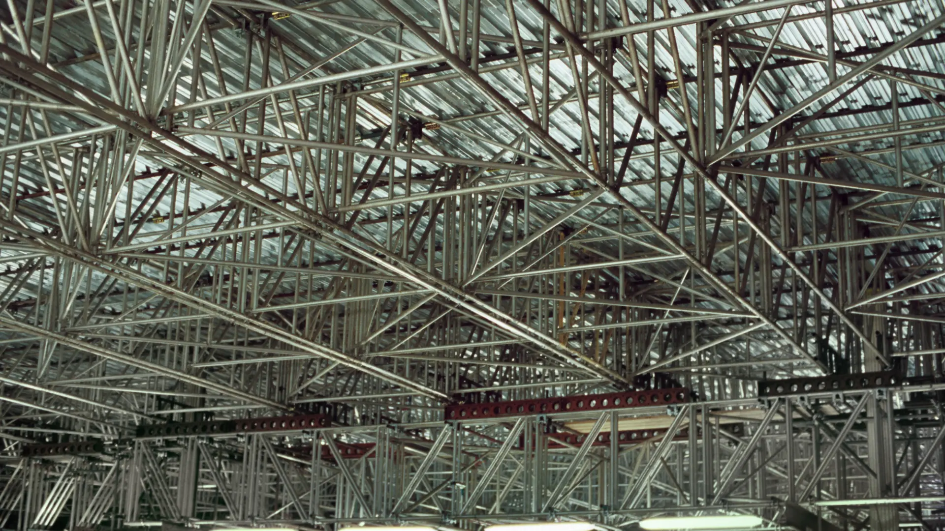 Suspended scaffold framework hung beneath a large roof structure for underside access