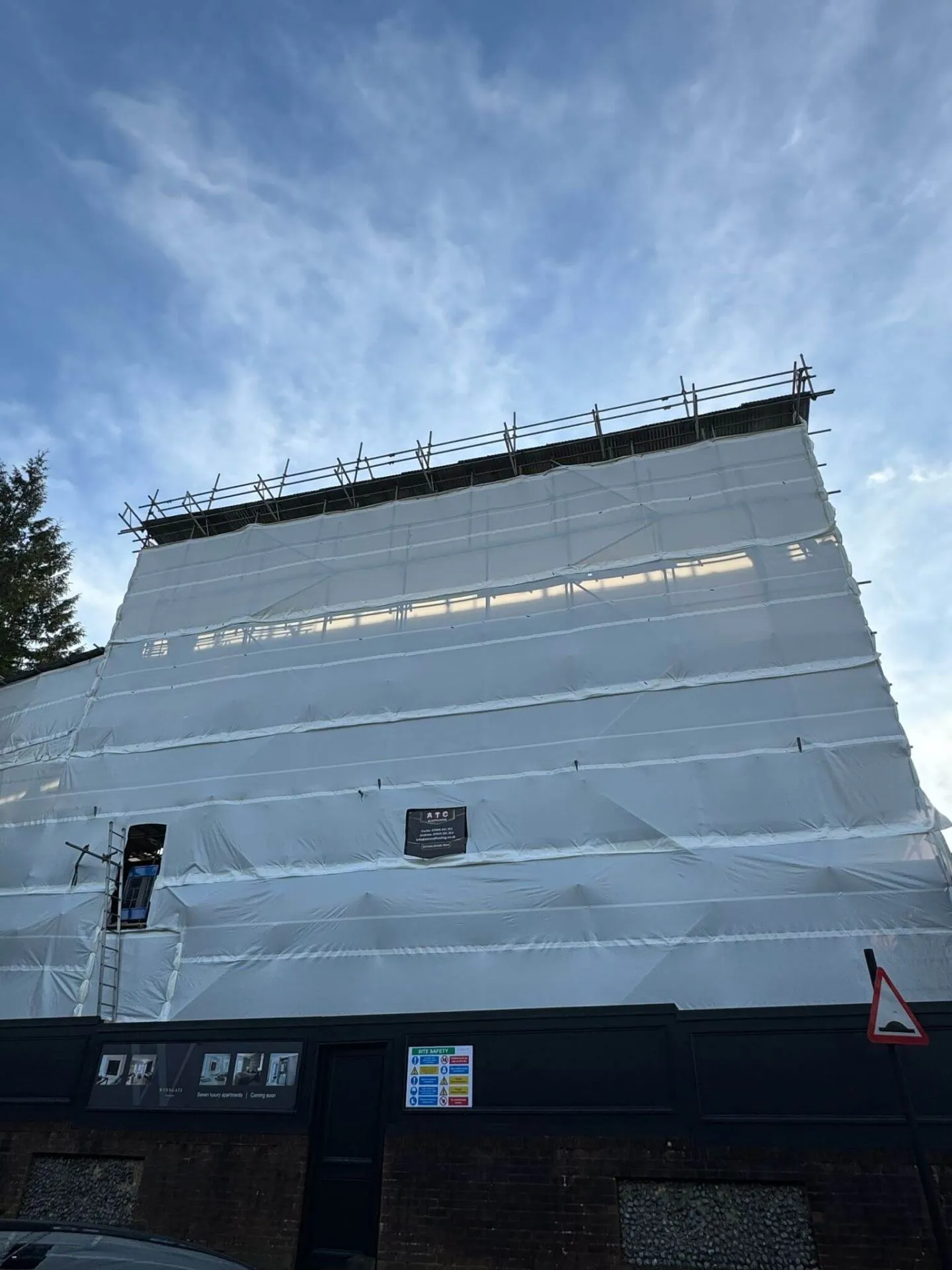 Temporary roof scaffolding with fully sheeted encapsulation keeping a building watertight during roof works
