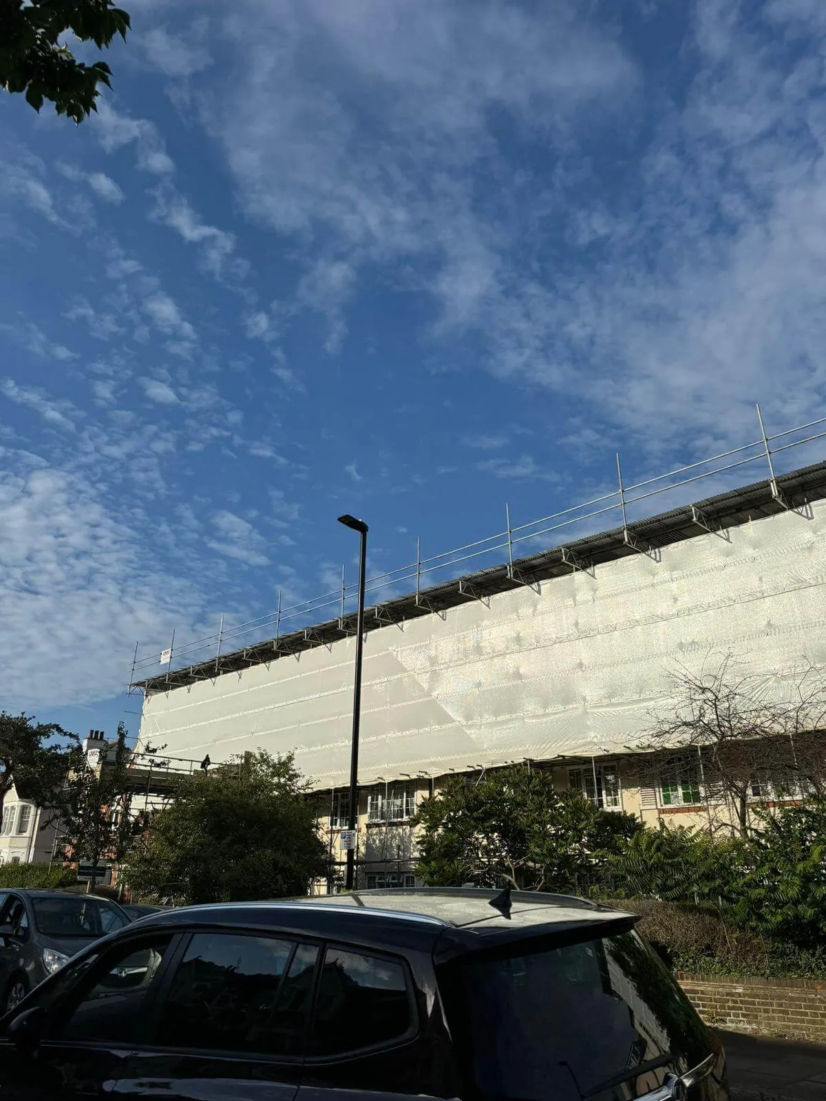 Temporary roof scaffolding with fully sheeted encapsulation keeping a building watertight during roof works